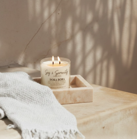 Sunlit coastal home candle by an open window casting soft natural shadows in a bright spring and summer space.