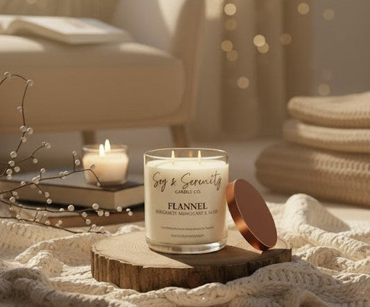 Flannel soy candle by Soy & Serenity displayed on a wooden tray with cozy blankets, soft lighting, and decorative winter accents, creating a warm and relaxing ambiance.