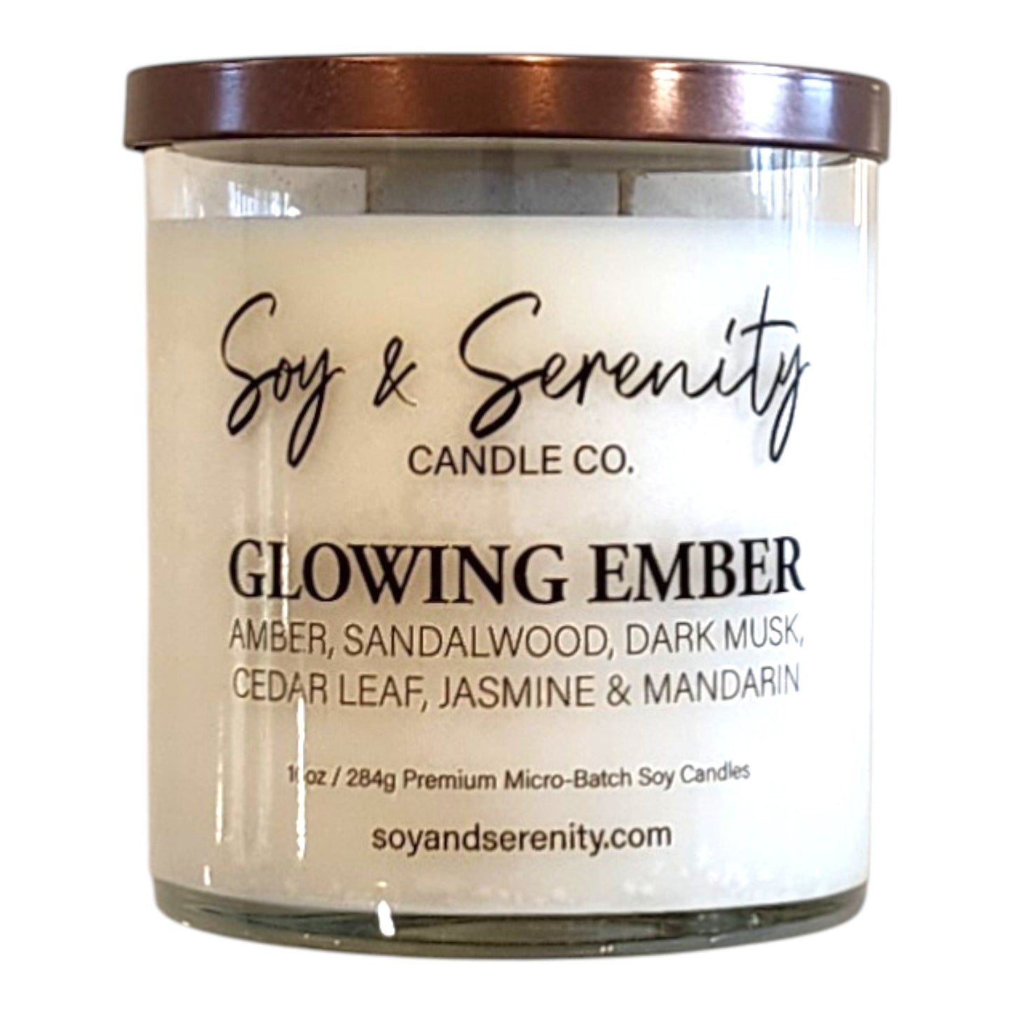 Glowing Ember amber soy candle in a clear glass jar on a white background, luxury candle.