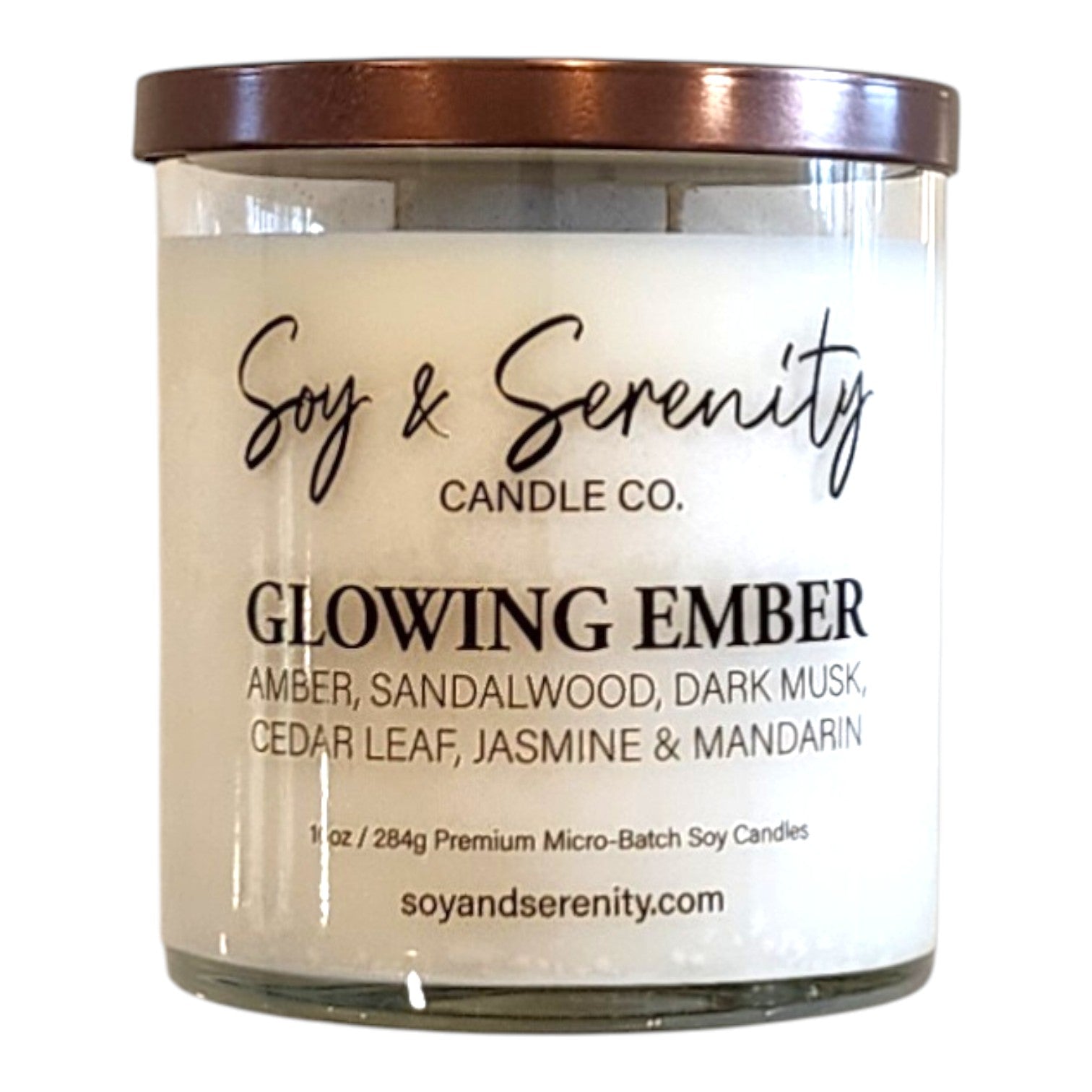 Glowing Ember amber soy candle in a clear glass jar on a white background, luxury candle.